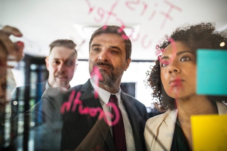 a group of people writing on a whiteboard learning How to Create a Simple 5-Point Business Plan