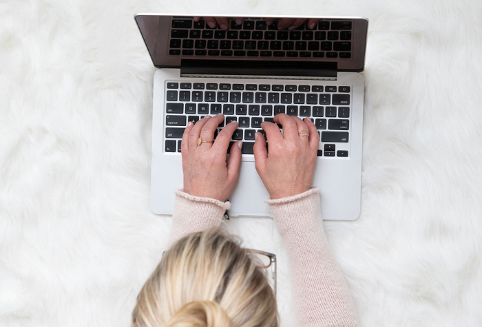 blonde woman typing on a computer at a desk