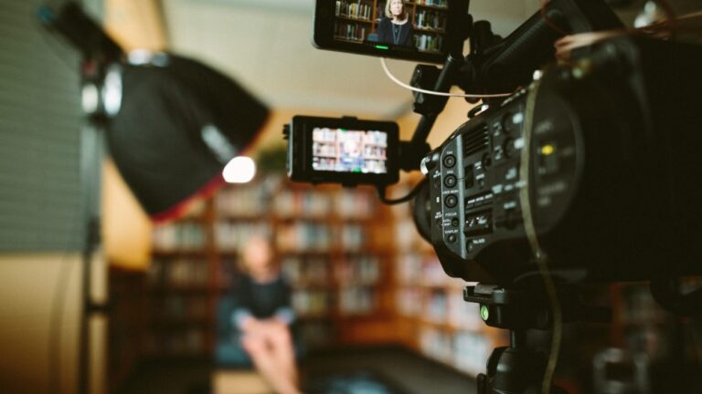 a video camera filming a woman in an office setting