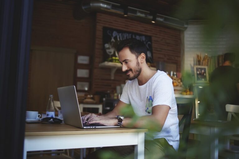 a man sitting at a laptop learning what tasks a freelancer should automate