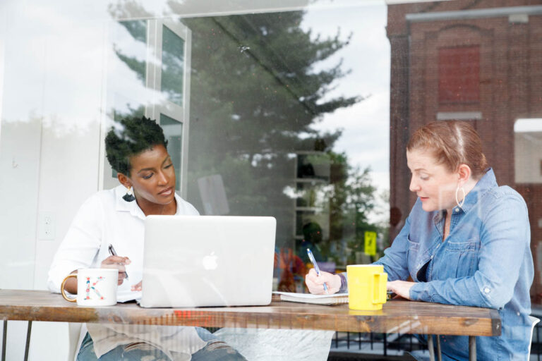 two people working on their schedule in a coffee shop