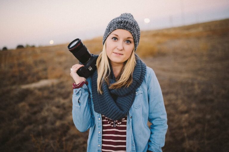 photographer holding her camera in a field