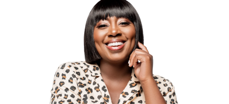 A headshot of a woman smiling. She has a bob haircut and wears a leopard print shirt.