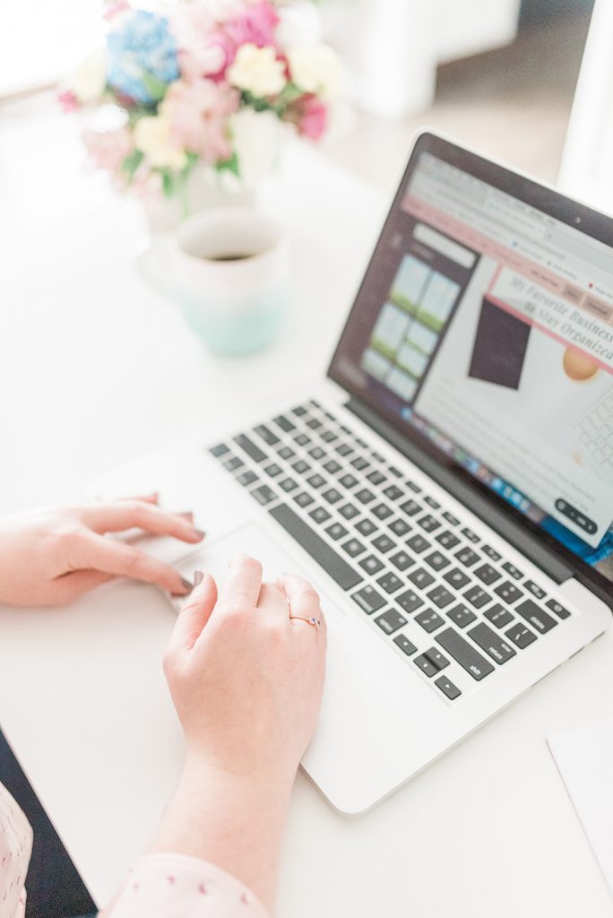 Close up of a woman's hands typing on a laptop.