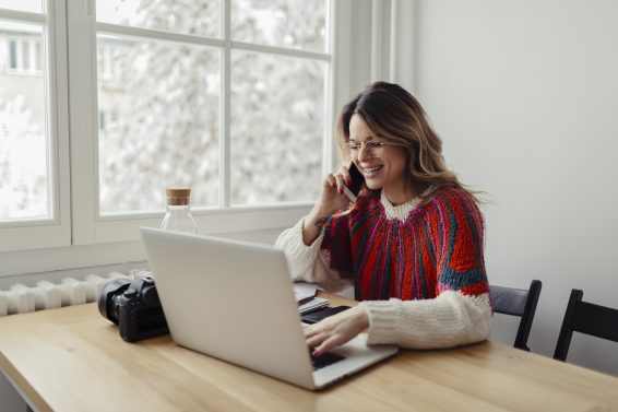 woman on the phone using a laptop learning about the Employee Retention Tax Credit