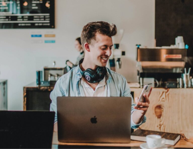 Man using small business software on his phone and laptop