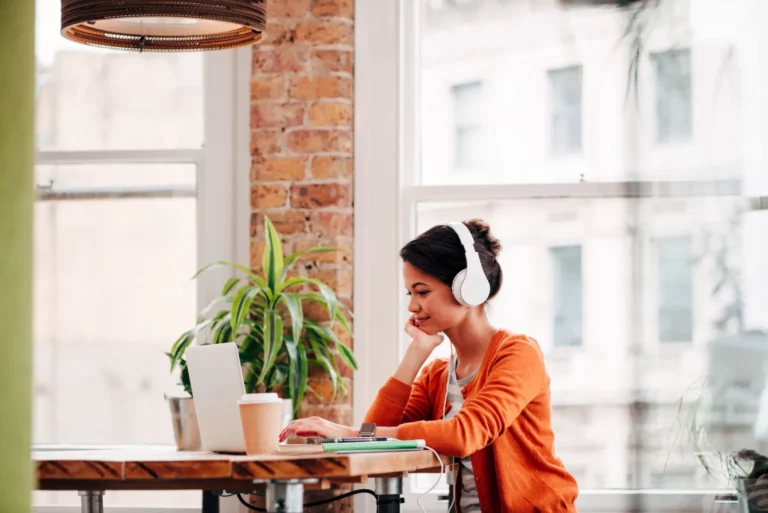 A woman sitting at a table working on her computer