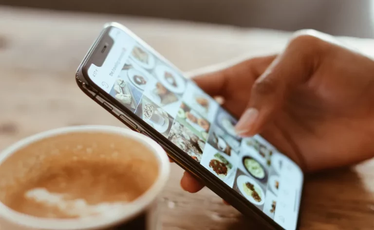 Person using their cell phone while having coffee