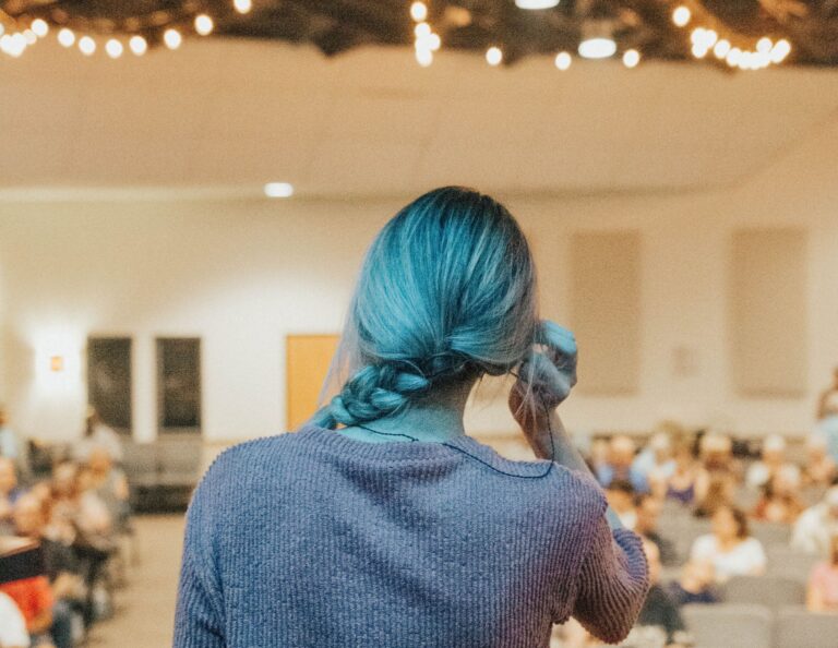 Woman speaks to crowd in an auditorium.