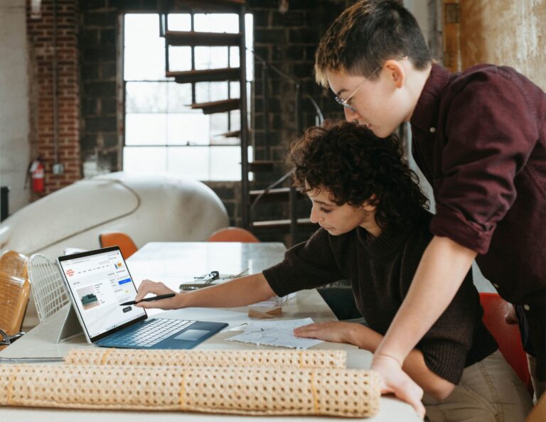 Two people map out ideas on a computer.