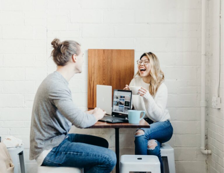 Man and woman talking and laughing over a table