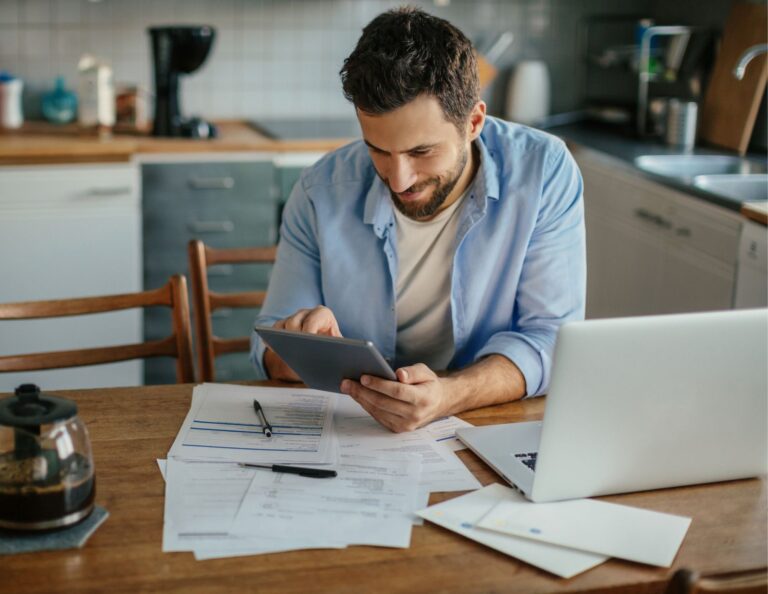 Man tracking invoice payments at his desk