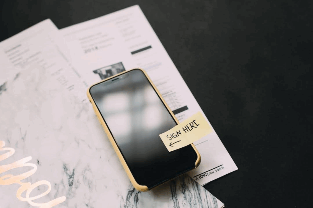 Current image: an iphone with a post-it note saying 'sign here'